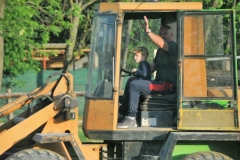 Father teaching his son how to drive a tractor.