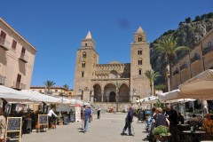 The Cathedral, begun in 1131, in a style of Norman architecture which would be more accurately called Sicilian Romanesque. The exterior is well preserved, and is largely decorated with interlacing pointed arches; the windows also are pointed. On each side of the façade is a massive tower of four stories. The Duomo or Cathedral dominates the town architecturally and spiritually, the vibrant Piazza Duomo below it is the hub of Cefalù‘s social life. Crowds gather here during the evening  to engage in discussion over a drink.