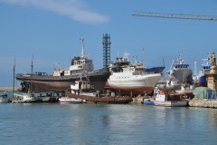 The harbor is busy with  repairs and maintenance on many ships.