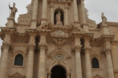 Siracusa's Duomo is one of the town's most celebrated sights. The building records the many ages of the town. Once it was the Greek Temple of Athena, with a giant gold statue of the goddess on its roof. The massive Doric columns of the temple are still visible; rather wonky after earthquake damage.