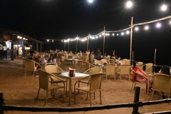 Guests dining by the ocean enjoying the warm even breezes off the ocean. 