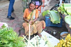 A local vendor with fruits, banana leaves to eat on and other items.