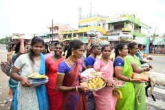 The ladies are bringing food, bananas and other dishes for the celebration. 