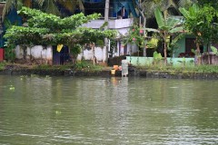 A local washing various items from the water in the canal. 
