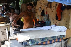 Here we have a young man ironing clothes.  He later showed me that the iron has hot coal inside the iron to keep it hot to iron the clothes as a living for him.. 