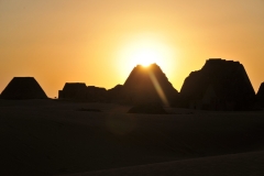 Sun setting on top of a pyramid