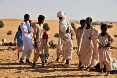 The young boys just stand to the side while the women work tirelessly