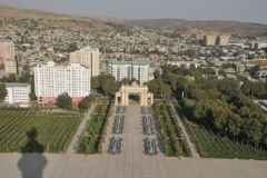 Looking at the Plaza below leading to the old Arch way leading off of a tree laden parkway in the city.