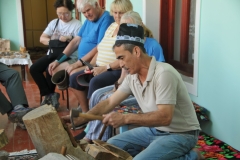 From a large piece of special wood he takes a piece of wood and begins a demonstration of his skill in creating a comb.