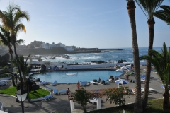 Lots of tourists enjoying the sun, beach and pool in an area that is private entrance with fees charged.