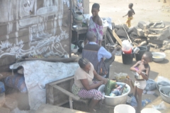 The lady is washing clothes. Not sure for money or for her family.
