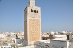  East of the Medina, through the Sea Gate, in the distance,  begins the modern part of the city called "Ville Nouvelle", traversed by the grand Avenue Habib Bourguiba, often referred to by media and travel guides as "the Tunisian Champs-Élysées", where the colonial-era buildings provide a clear contrast to smaller, older structures. The large squared minaret is found at Al Zaytuna Mosque. 