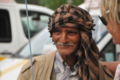 Interesting looking gentleman have a conversation with friends most likely. 