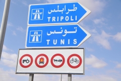 Notice the 4 red circles, at the bottom of the highway sign,  of items you cannot do. Bring in a Tractor from Libya. They are much cheaper there. Cannot bring in a bomb ok. No horse driven horse and buggy and bicycle strangely.  