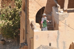A resident sweeping a walkway