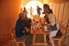 On our way to the desert area we stop at the Berber town of Matmata  to experience their fascinating troglodyte houses, man made caves dug out of large pits in the ground.  We are just sitting down to enjoy our lunch in one of the cave homes. 
