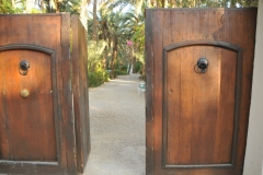 The large wooden gates open to a beautiful interior landscape flush with plants and trees and one crazy rooster that roamed all night and slept in the day time I think. 