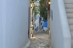 Typical narrow walk way with white walls and blue window shades