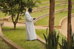 A Catholic Father from the church taking a respite in the afternoon sun or the day outside the Basilica.
