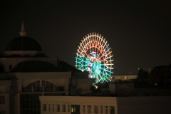 Light Ferris wheel across the city.