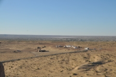 Looking down from the top of the former fortress to the end of the road and a small hut encampment to stay and our bus parked.