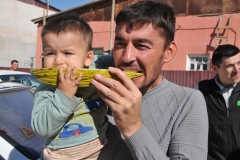 Local father and son enjoying a sample taste of some good locally grown melons.  I tired it and it was great.